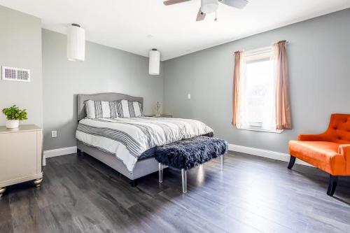 - une chambre avec un lit et une chaise orange dans l'établissement 3BR Gem Near Falls-Sleeps 6 Comfortably, à Niagara Falls