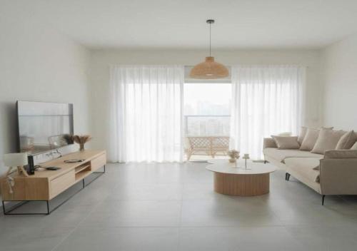 een woonkamer met een bank en een tafel bij O&O Group Luxury Tower 4BR Panoramic Sea Views in Bat Yam