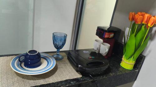 un tavolo con un frullatore, un piatto e un bicchiere di Flats containers a Rio Verde