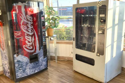 a cocacola machine next to a vending machine at Cole Manor Motel By OYO Love Field Market Center in Dallas