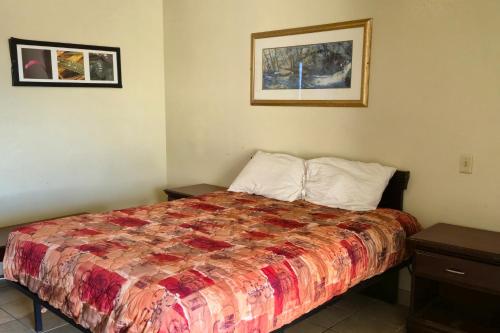 a bedroom with a bed with a quilt on it at Cole Manor Motel By OYO Love Field Market Center in Dallas