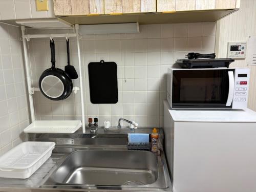 a kitchen with a sink and a microwave at Silver Heights 3rd floor 302,303,304 - Vacation STAY 60218v in Osaka