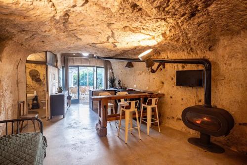 een keuken met een tafel en een fornuis in een grot bij Le Cavernacle in Montrichard