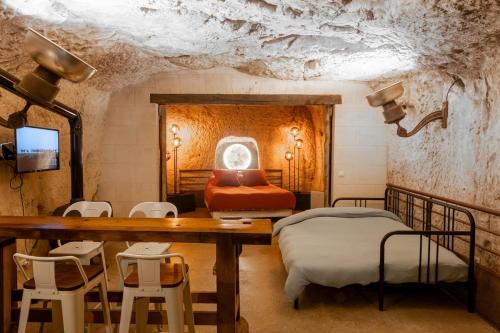 a bedroom with two beds and a table and chairs at Le Cavernacle in Montrichard