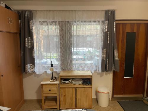 a room with a window with curtains and a table at Chatky U Davida Máchovo jezero in Staré Splavy