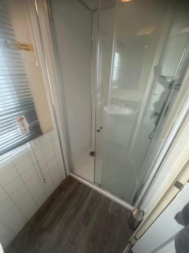 eine Dusche mit Glastür im Badezimmer in der Unterkunft Meadow view 93 8 berth Chapel, Skegness SANTANAVAN 15 in Chapel Saint Leonards