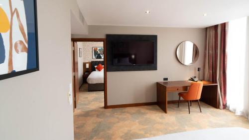 a hotel room with a desk and a television at Holiday Inn Bristol City Centre by IHG in Bristol
