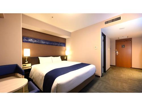 a hotel room with a large bed and a desk at Smile Hotel Premium Kanazawa Higashiguchi Ekimae - Vacation STAY 65344v in Housai