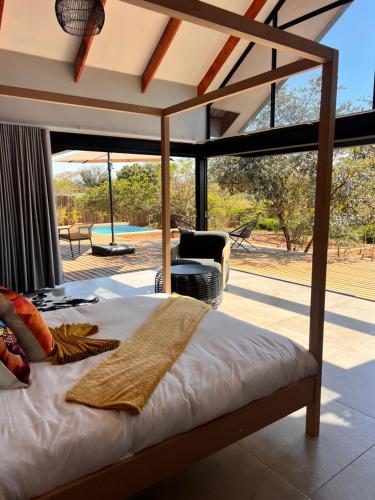 a bedroom with a bed and a view of a yard at Makonde river lodge in Makonde