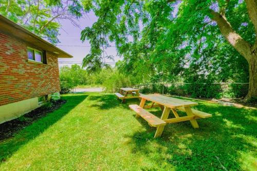 a picnic table and bench in the grass next to a building at 5BR House Close to Falls & Aquarium in Niagara Falls
