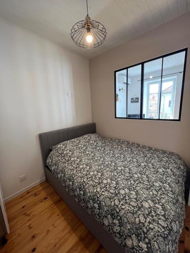 een slaapkamer met een bed en een raam bij Studio centre ville in Bourgoin