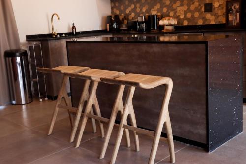 a kitchen with a counter with two wooden stools at Makonde river lodge in Makonde