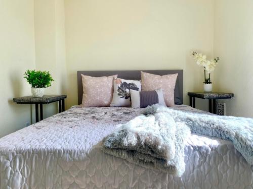 ein Schlafzimmer mit einem großen Bett mit rosa und lila Kissen in der Unterkunft 5BR Niagara Getaway Prime Location-Sleeps 10 in Niagara Falls