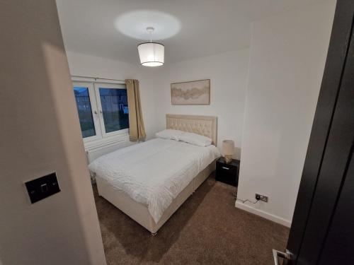 エディンバラにあるEdinburgh West Luxury 5 Bedroom Homeのベッドと窓のある白い寝室