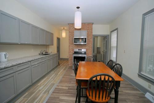 a kitchen with a wooden table and some chairs at Perfect 6BR Stay Near Falls & Attractions in Niagara Falls