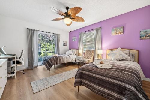 a bedroom with two beds and a purple wall at Sunset Sands Retreat in Venice