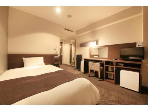 une chambre d'hôtel avec un lit et un bureau dans l'établissement Smile Hotel Tokyo Ayase Ekimae - Vacation STAY 62870v, à Tokyo