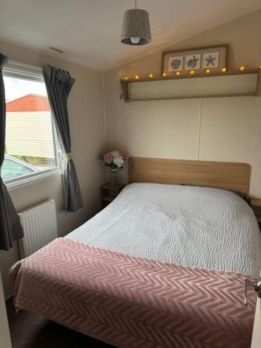 une chambre avec un lit et une fenêtre dans l'établissement Seaside Charm Cabin Retreat in Rhyl, à Rhyl