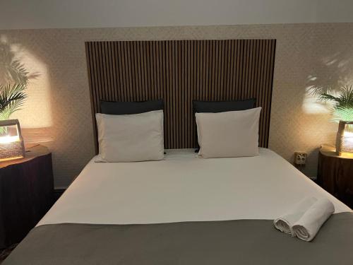 a bedroom with a large bed with white sheets and pillows at Cactus Host in Las Palmas de Gran Canaria