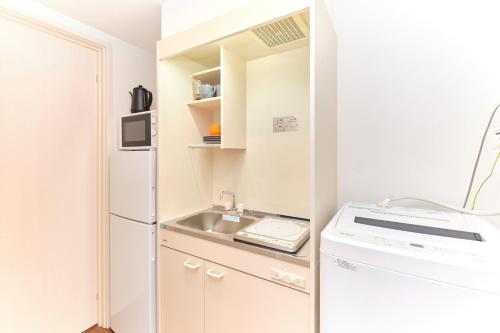 Una pequeña cocina con fregadero y refrigerador. en le cocon Nakarokugo - Vacation STAY 17419v, en Tokio
