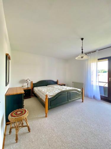 a bedroom with a bed and a table and a chair at Ferienwohnung Blautalblick in Blaustein