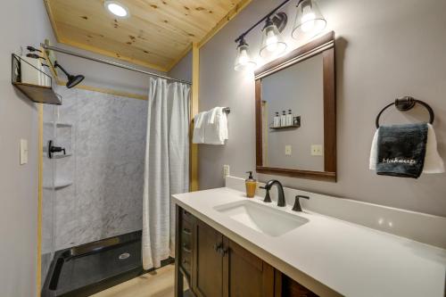 a bathroom with a sink and a mirror and a shower at Hot Tub and Pet-Friendly! Gatlinburg Resort Cabin in Gatlinburg