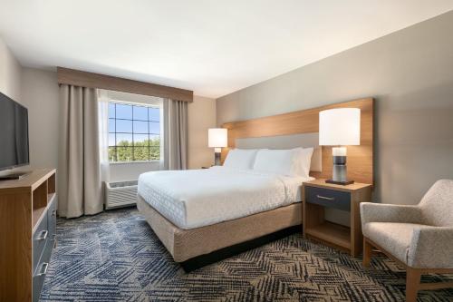 a hotel room with a bed and a chair at Candlewood Suites Annapolis by IHG in Annapolis