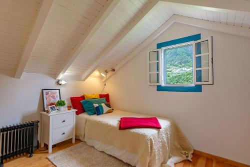 ein Schlafzimmer mit einem Bett und einem Fenster in der Unterkunft The Yellow Cottage Nature House São Vicente Madeira Island in São Vicente