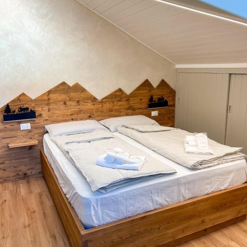 a large bed with white sheets and towels on it at Harmonia Suite & Apartments in Giustino