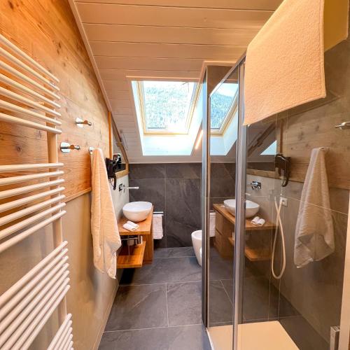a bathroom with a sink and a toilet and a window at Harmonia Suite & Apartments in Giustino
