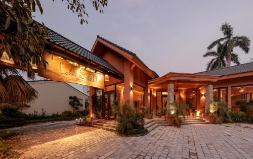 an exterior view of a building with a brick courtyard at La Sen Village in Ninh Binh