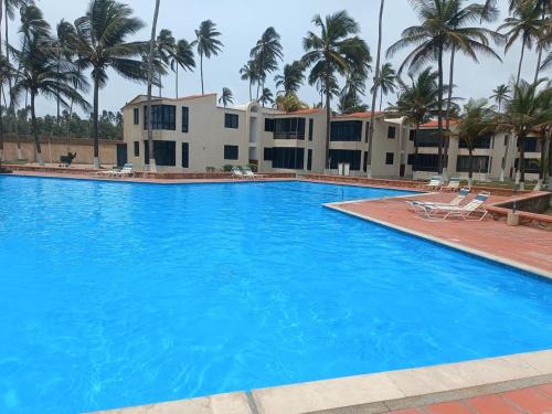 ein großer blauer Swimmingpool vor einem Gebäude in der Unterkunft Apartamento con vista al mar Tucacas in Tucacas
