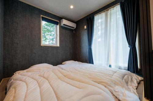 a bedroom with a large bed with a window at Pino - Vacation STAY 20287 in Yamanakako