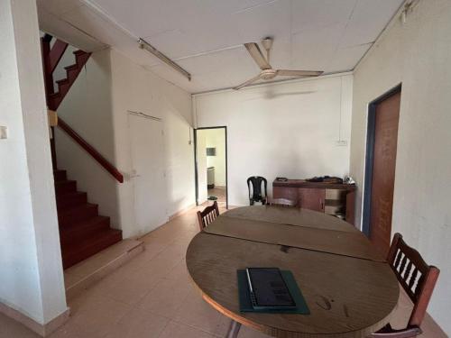 a room with a table and chairs and a staircase at RUMAH BENDANG ALOQSETAQ -Private PooL - Panoramic view of rice fields and Alor Setar Tower in Alor Setar