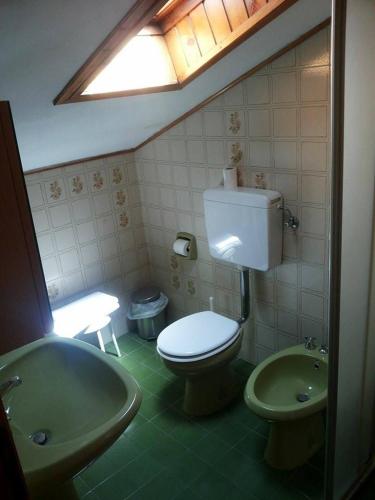 a bathroom with a toilet and a sink and a tub at Hotel Piol in Limana