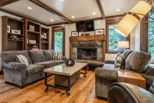 ein Wohnzimmer mit Sofas und Kamin in der Unterkunft Cedar Crest - Owl Cottage 9 in Homewood