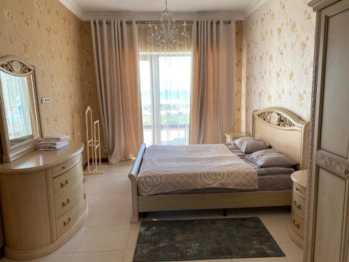 a bedroom with a bed and a dresser and a window at Коттедж - Вилла in Chok-Tal