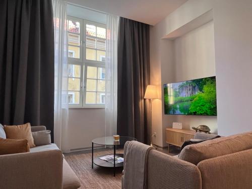 a living room with a couch and a tv at Suite Nr 4 - J26 LUXURY APARTMENT, Jauniela 26 Old Riga - TOP Location - 2BDR - 80m2 in Rīga