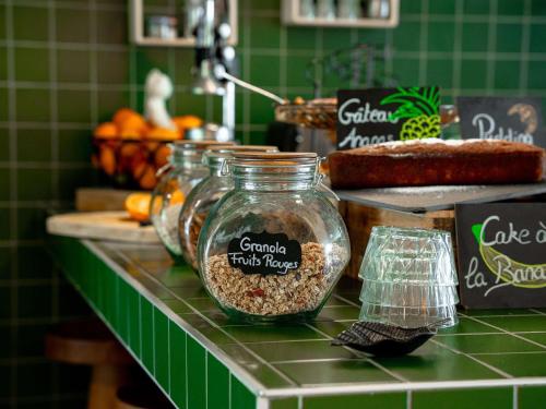 モーギオにあるGreet hôtel Montpellier Aéroport Parc des Exposのカウンターの上に食品の入った瓶が3つ置かれているカウンター