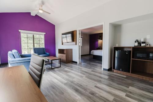 a living room with purple walls and a couch and a tv at La Quinta Inn by Wyndham Amarillo Mid-City in Amarillo