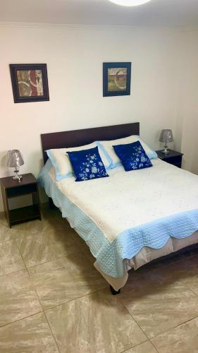 a bedroom with a large bed with blue pillows at Valparaiso's Best in Valparaíso