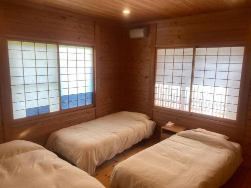twee bedden in een kamer met twee ramen bij CocoKaidakogen - Vacation STAY 54032v in Yoriaido