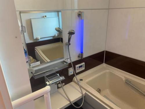 een badkamer met een ligbad en een spiegel bij CocoKaidakogen - Vacation STAY 54032v in Yoriaido
