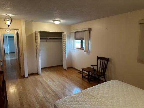 a bedroom with a bed and a chair in a room at Cozy Farmhouse B&B Retreat in Williams Lake