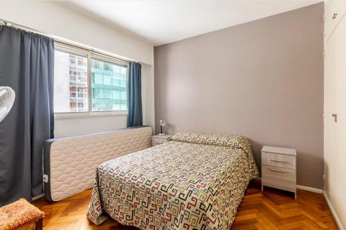 a bedroom with a bed and a window at Moderno departamento en Cañitas in Buenos Aires