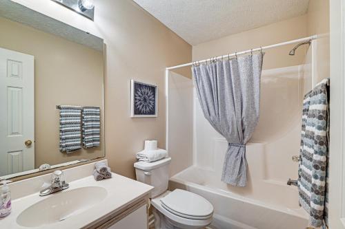 a bathroom with a toilet and a sink and a shower at Pawleys Island Condo with Screened Porch and Golfing! in Pawleys Island