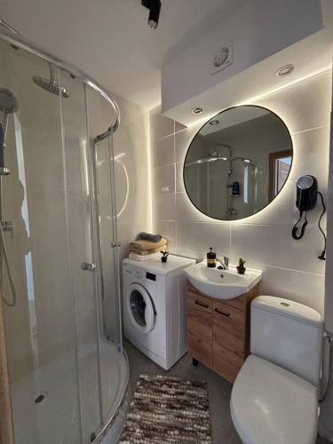 a bathroom with a sink and a washing machine at Apartament w Centrum Miasta in Brodnica