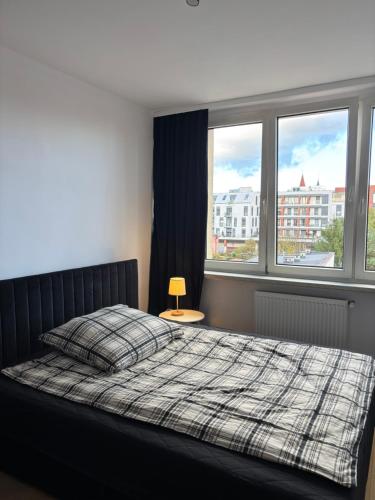 a bedroom with a bed and two windows at Apartament w Centrum Miasta in Brodnica