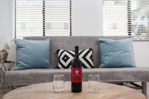 a bottle of wine sitting on a table with two glasses at Sunny 1 Bedroom in the Heart of Venice Beach - #4 in Los Angeles
