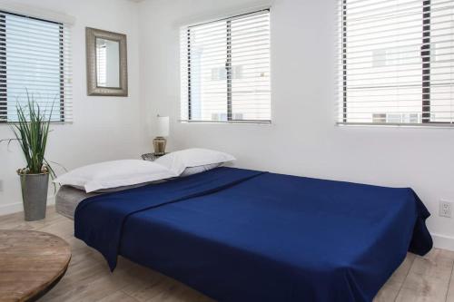 a blue bed in a white room with windows at Sunny 1 Bedroom in the Heart of Venice Beach - #4 in Los Angeles